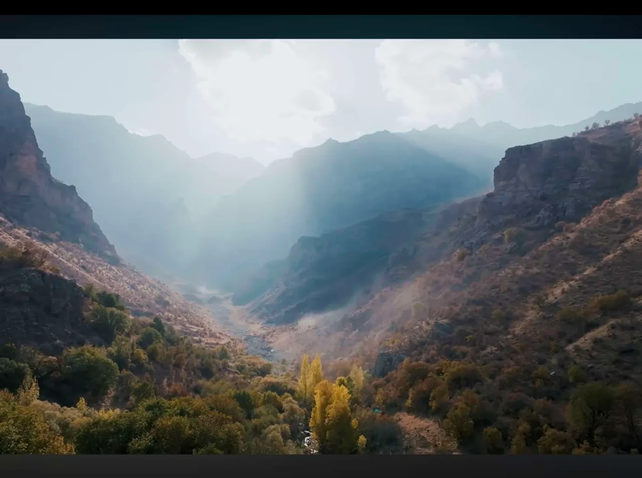 Cinematic drone frame of a mountain valley from the YouTube series